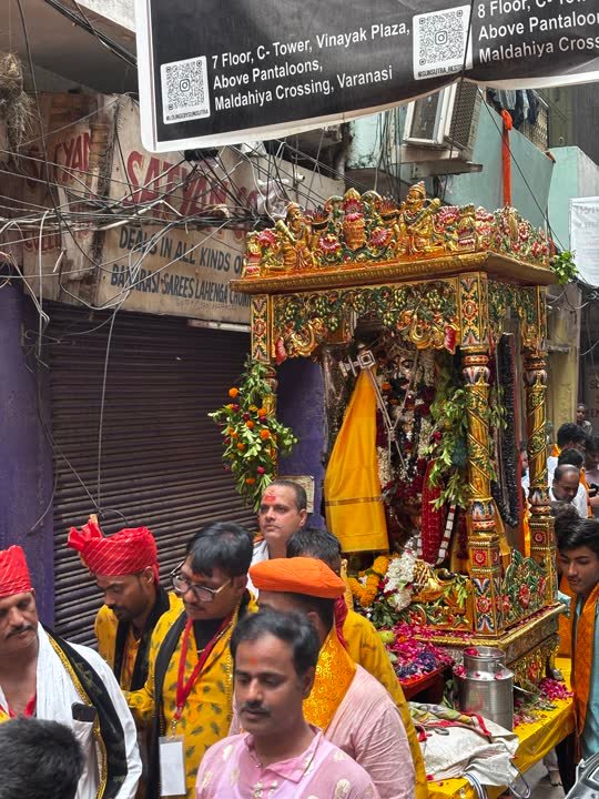 Decorated palanquin carried through a lane during a festival procession